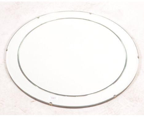 A 1930's Art Deco circular frameless mirror with ridged detaling. Wooden back panel with chain. Measures 55.5 cm diameter.