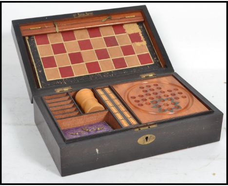 A 19th century games compendium set housed within a wooden case to include chess, draughts, dominoes, solitaire, rubicon, pla