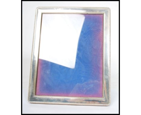 A large silver hallmarked easel picture frame, rope border, blue velvet back with central glass panel. Birmingham assay mark,