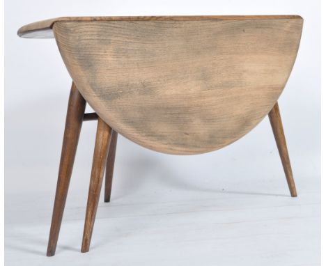 An Ercol retro 1970's drop leaf circular coffee - occasional table by Ercol raised on tapered legs with chamfered edge table 