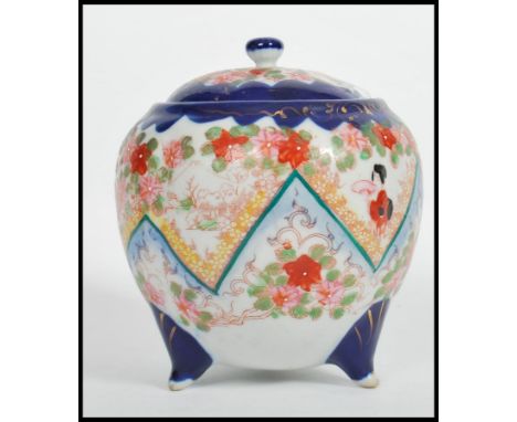 A vintage early 20th century Japanese ceramic lidded biscuit barrel having painted floral decoration depicting Geisha's raise