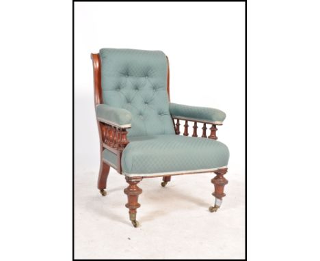 A Victorian mahogany upholstered library chesterfield armchair raised on turned legs with castors. Good green fabric upholste