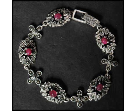 A 925 silver&nbsp; Art Nouveau style bracelet set with ruby cabochons and marcasite having a clip clasp. Marked 925. Measures