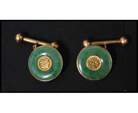 A pair of vintage Chinese 18ct gold and jade cuffs / cuff links of roundel form having ball ended bards. Weighs 8.6 grams.