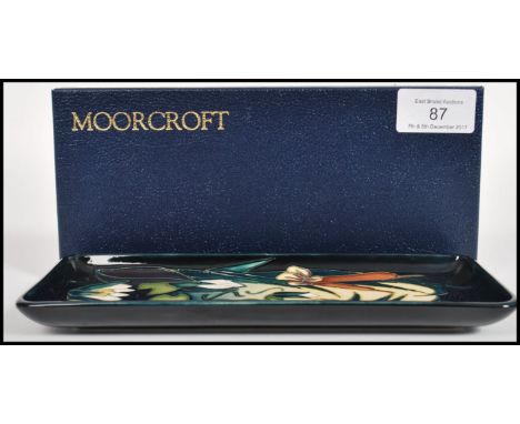 A Moorcroft ceramic pin tray of rectangular form tube lined decorated with flowers complete in original box C95 leaf mark and