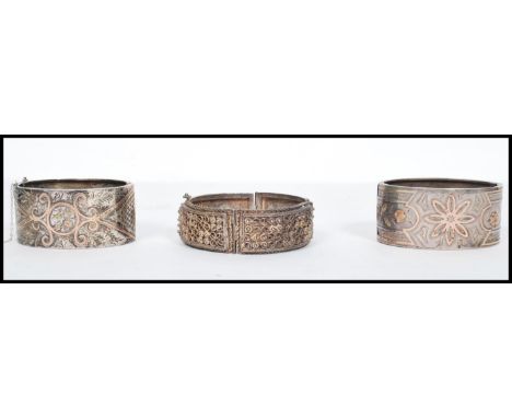 A group of three silver bangles to include a pair of 19th century hallmarked silver Victorian bangles of large form having 9c