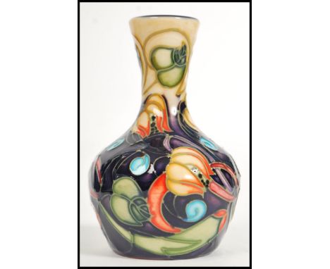 A Moorcroft ceramic vase tube lined decorated with flowers in the Celtic Web pattern complete in original box C2002 scissor m