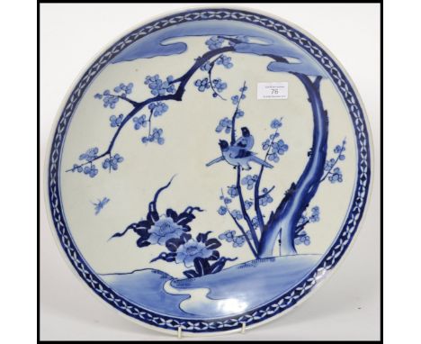A 19th century blue and white Chinese ceramic charger plate depicting flowers and birds.&nbsp;Measures 41cm wide.
