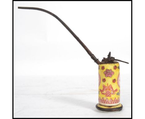 An early 20th century Chinese ceramic water opium pipe having a ceramic body with a famille jaune ground with ochre red decor