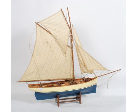 A vintage 20th century scratch built model of a sailing boat raised on the original wooden display stand. The boat being well