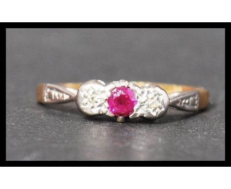 A 18ct gold platinum ruby and diamond three stone ring having stylised shoulders. Marked 18ct tests 18ct. Weighs 1.9 grams si