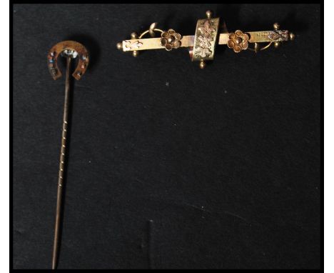 A 19th century 15ct gold stick pin along with a 9ct gold bar brooch. The pin with horse shoe to top and the bar brooch with f