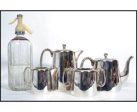 A vintage 20th century four person silver plated tea service along with a vintage mid century soda siphon.