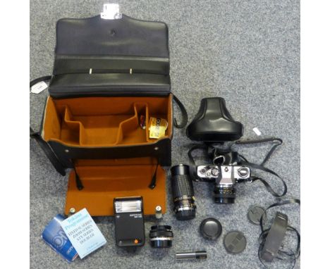 A cased Olympus OM10 camera with spare lenses including Pressman Zoom Auto No. 821296