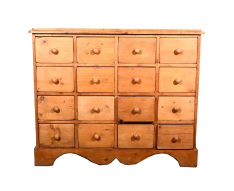 A pine collectors cabinet, with four rows of four drawers, shaped apron, bracket feet, width 112cm, depth 35cm, height 93cm.