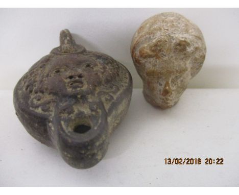 A Hellenistic style terracotta head 1 1/2" h and a Roman style pottery lamp decorated with the face of a child with fruiting 