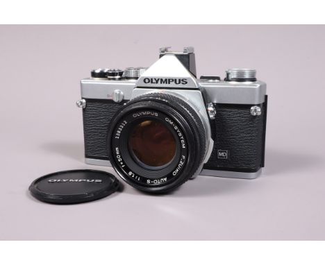 An Olympus OM 1n SLR Camera, serial no 1754963, shutter working, meter responsive, self timer working, body G, light marks to