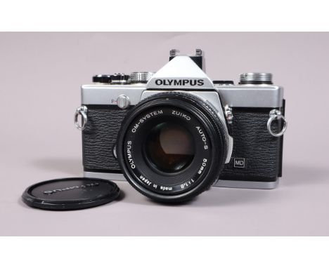 An Olympus OM 1n SLR Camera, serial no 1854055, shutter working, meter responsive, self timer working, body G-VG, with Zuiko 