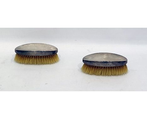 Pair of silver-backed hairbrushes of oval form with engine-turned decoration