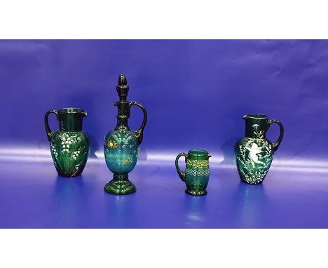 Victorian green glass jug with white enamel decoration in the style of Mary Gregory of a cherub, another similar jug decorate