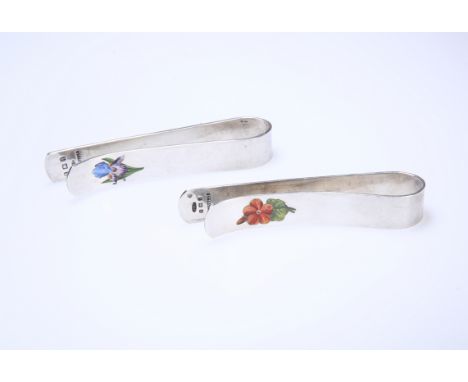 A PAIR OF EDWARDIAN SILVER AND ENAMEL TABLECLOTH CLIPS, BIRMINGHAM 1908, of characteristic form, each enamelled with a flower