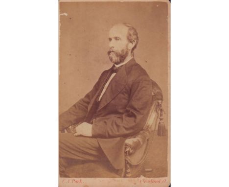 Albumen print portrait of a victorian man seated in turn position, elegantly dressed. Information of photographer on verso of