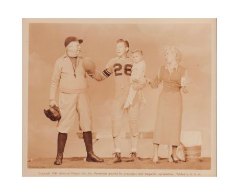 Portrait of a football player holding a child. His wife is to his left and his coach to his right. Football and Family. Coach