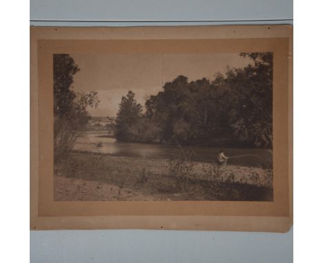Salt print mounted on board featuring a man fishing alongside a creek with a small white clapboard farmhouse in the backgroun