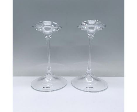 An elegant pair of clear candlesticks featuring a rounded base, a slender stem, and a cymbal-shaped top with a candle holder.