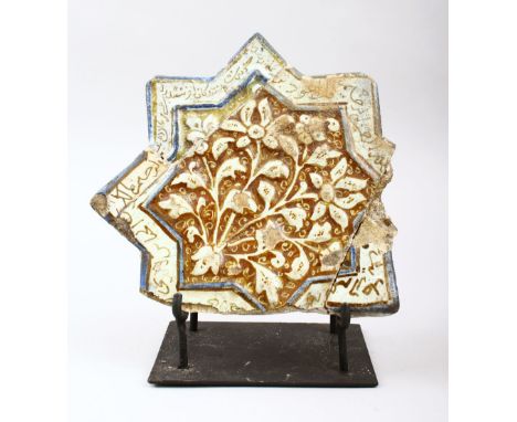 AN EARLY ISLAMIC KASHAN STAR TILE on a metal stand, with moulded floral decoration and calligraphic band, tile 18.5cm x 19.5c