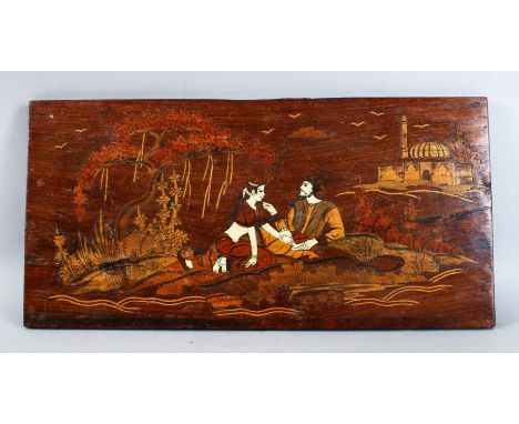 AN INDIAN / PERSIAN CARVED WOODEN AND INLAID PANEL, depicting two figures seated exterior, possibly inlaid with bone 51cm wid