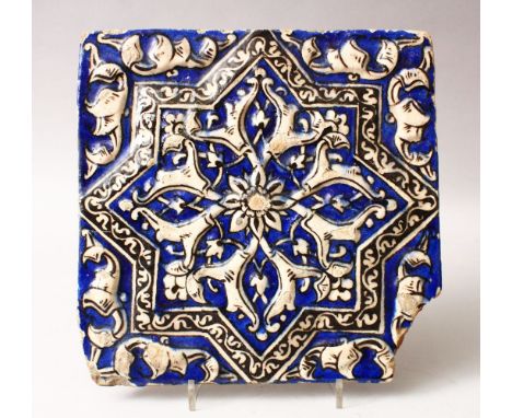 AN 19TH CENTURY OR EARLIER PERSIAN POTTERY MOULDED TILE, depicting floral designs (af), 24cm square.