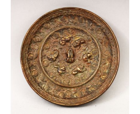 A GOOD 19TH CENTURY OR EARLIER CHINESE BRONZE MIRROR, of circular form, with cast beast and grape decoration 13cm diameter.