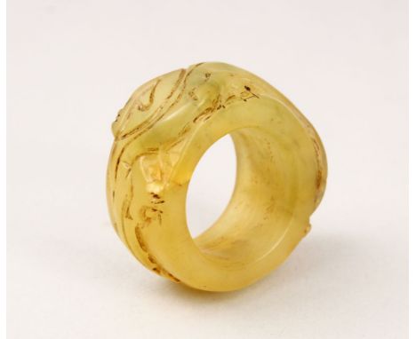 A GOOD CHINESE CARVED HARD STONE / JADE LIKE ARCHERS RING, with carved decoration, 4.5cm.