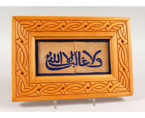 A 19TH CENTURY SPANISH ISLAMIC CALLIGRAPHIC FRAMED TILE PANEL, with raised calligraphy in blue poly chrome, 20cm x 30 cm