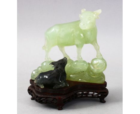 A GOOD CHINESE CARVED JADE / HARDSTONE FIGURE OF A COW AND CALF, stood on a fitted hardwood base, 15.5cm x 13.5cm wide.