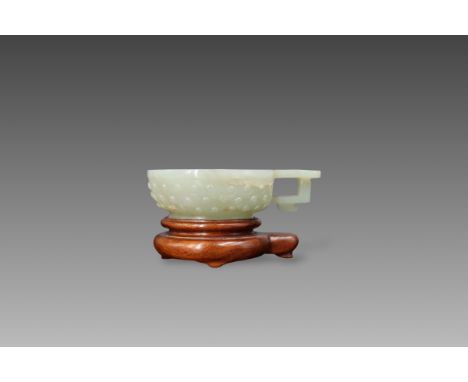 A Celadon Jade Cup with a Handle, 17th century ,wood stand Jade: L:8.5cm, W:6.2cm, H:2.4cm Some natural  lines, mostly faint,