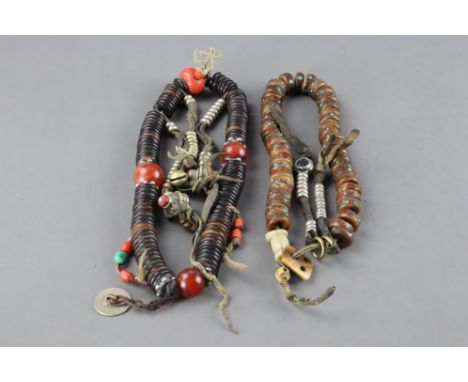 one with dark old  beads, which are of rounded disc form, strung on leather; the other with smaller pale rounded beads, strun