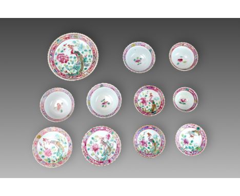 comprising five cups and six saucers in various sizes, each well decorated in 'famille rose' enamels with a central Phoenix a