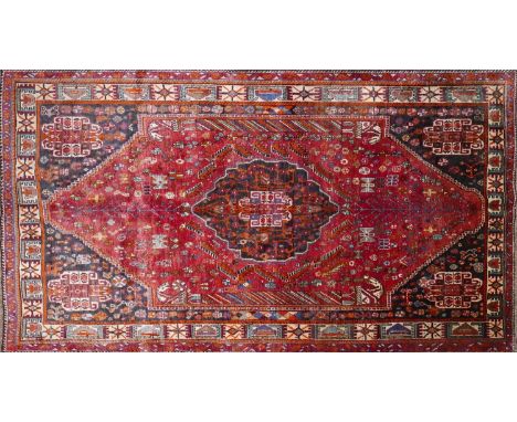 A South West Persian Qashqai carpet, central diamond medallion with four corner medallions with repeating petal and animal mo