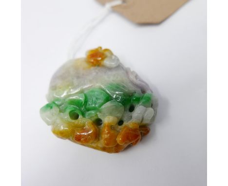 A large Chinese carved jade pendant adorned with a beast devouring a large fruit in veined hues of orange, green and lilac ja