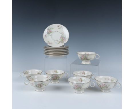 Features a set of 7 teacups and saucers with a delicate floral pattern and gilded gold accents. Teacups measure 4.75"L x 4"W 