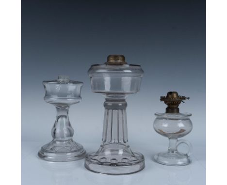 Amazing collection of old age glass bodied oil lamps that includes a pedestal stemmed lamp with star patterned around the bas