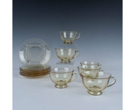 A lovely set of six translucent topaz-colored glass cups and matching saucers, featuring a simple yet elegant panel decoratio