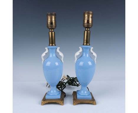 Glossy cornflower blue bulbous base with two white sculptural winged handles. Top and bottom of the lamps are brass featuring