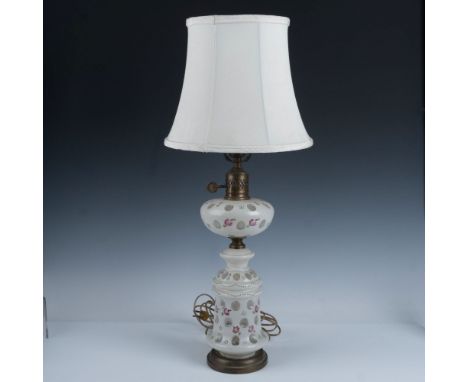Delicate floral design hand painted over white glass accented with raised green garlands set on brass round base. Twist switc