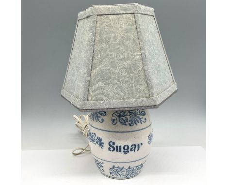 Pottery lamp with brass housing with Sugar and scroll design colored in blue. Push toggle switch for light function. Lamp com