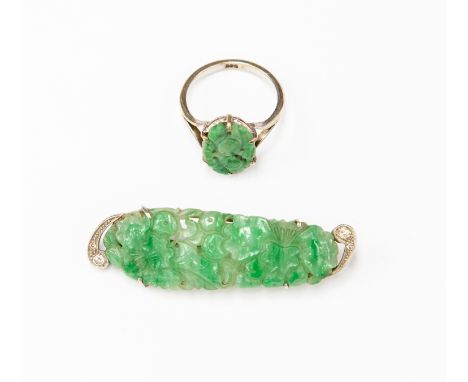 An Art Deco jade and diamond brooch, the carved and pierced jade flanked by terminals set with two diamonds, approx 5cm long,