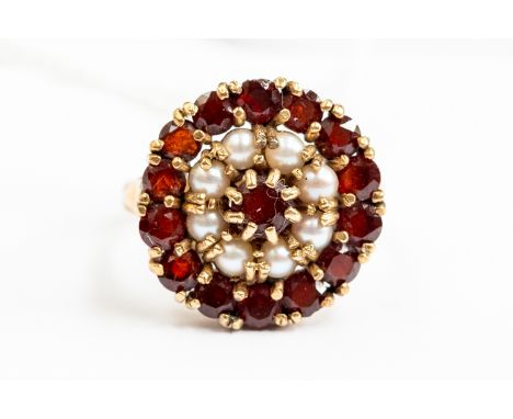 A 9ct gold garnet and pearl set circular dress ring, diameter approx 1.9cm, size O, gross weight approx 5.5gms