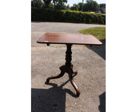 An early Victorian mahogany tilt top tripod table, circa 1850, the square top raised on a turned column, standing on three le